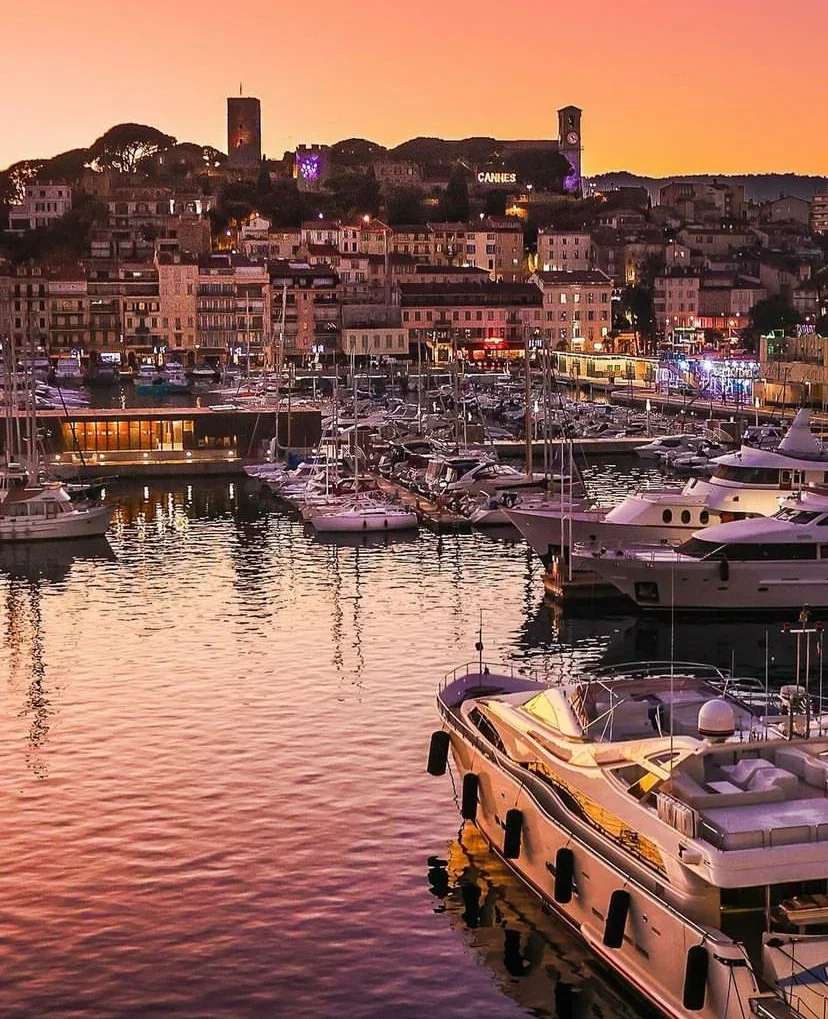 Boats in Cannes harbour below the old town at sunset