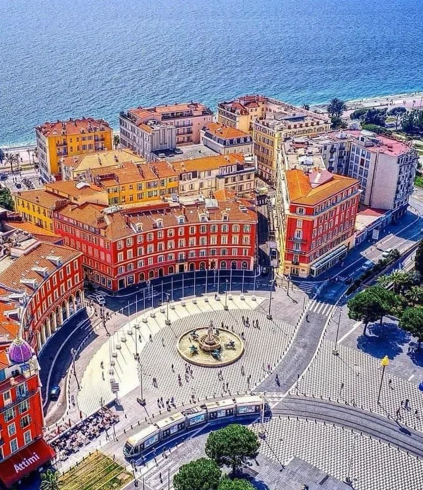 Aerial view of Place Massena in Nice with colourful buildings and the Mediterranean Sea